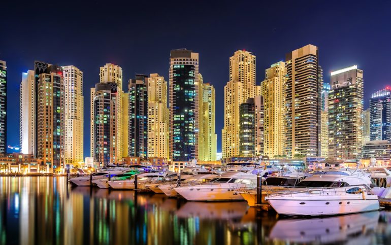 Colorful night dubai marina skyline. Luxury yacht dock. Dubai, United Arab Emirates.